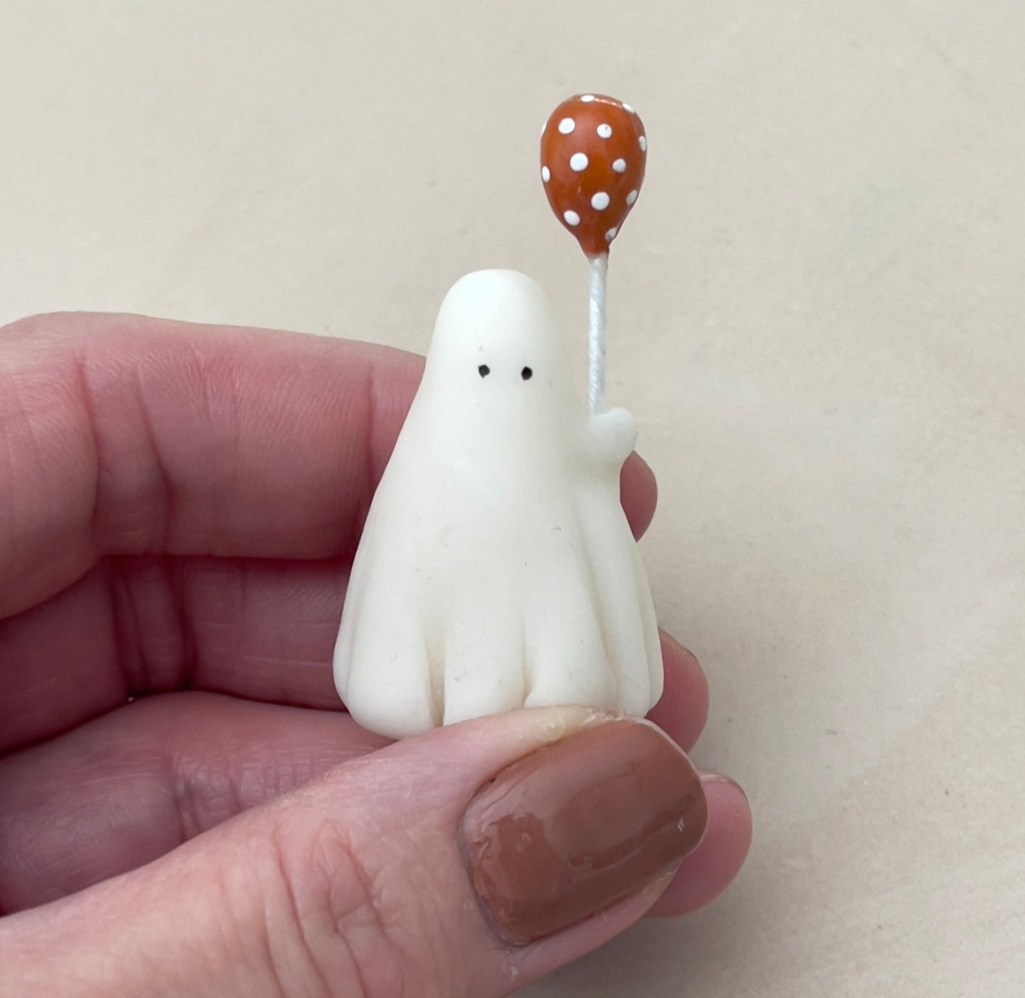 Miniature ghost with orange polka dot balloon