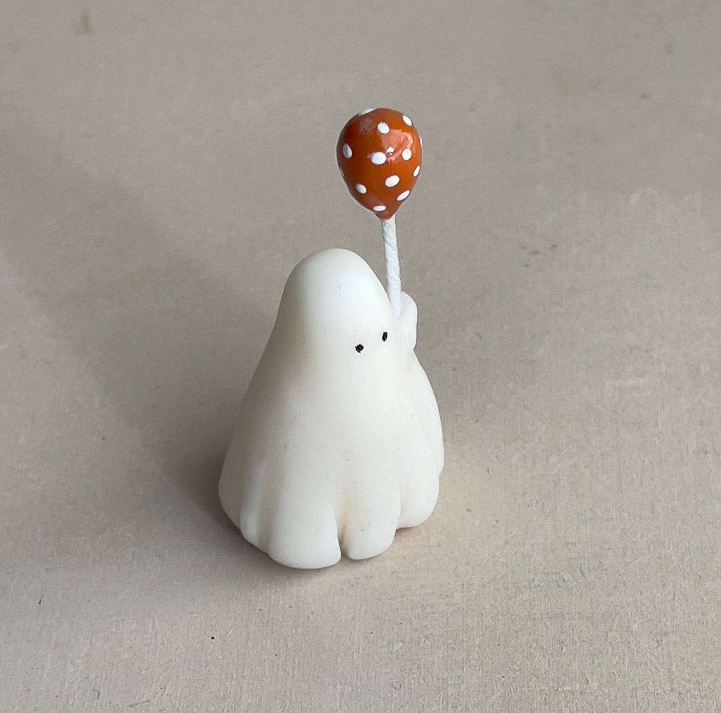 Miniature ghost with orange polka dot balloon
