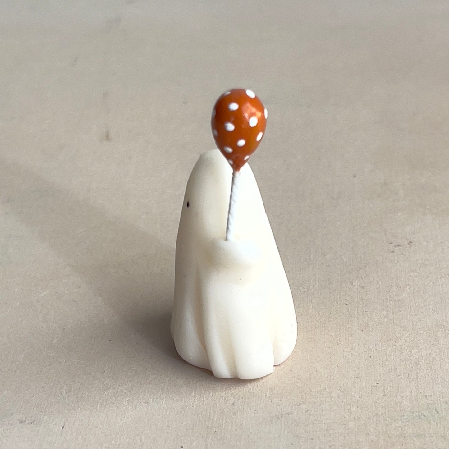 Miniature ghost with orange polka dot balloon