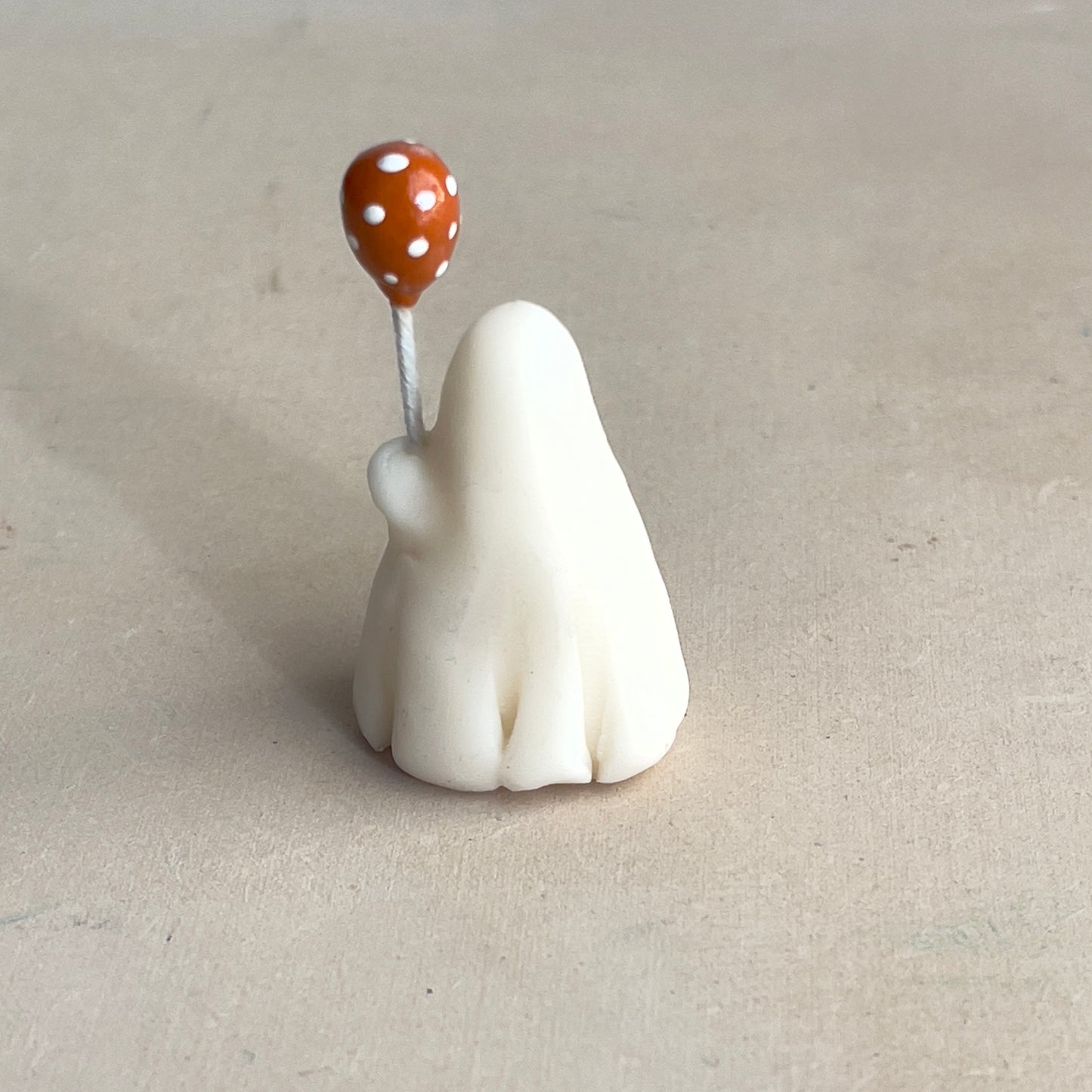 Miniature ghost with orange polka dot balloon