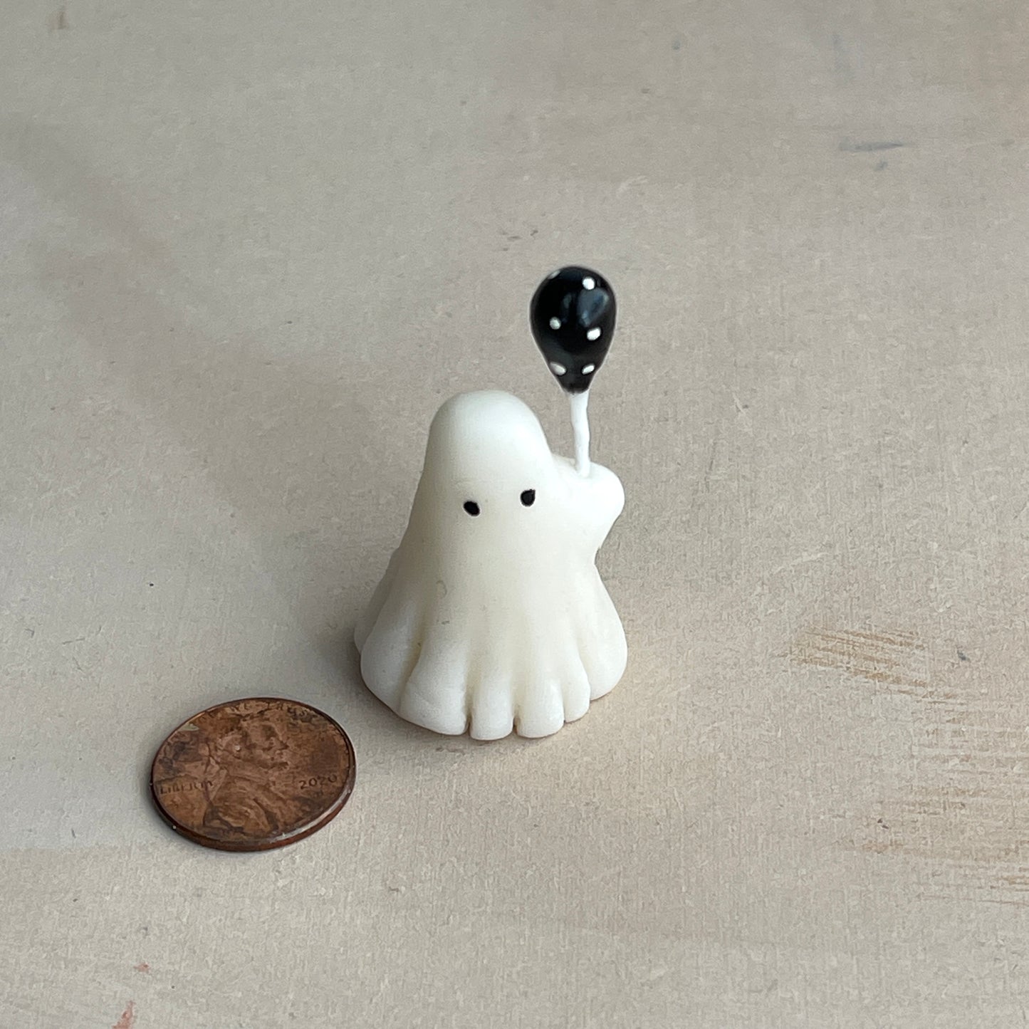 Miniature ghost with black polka dot balloon