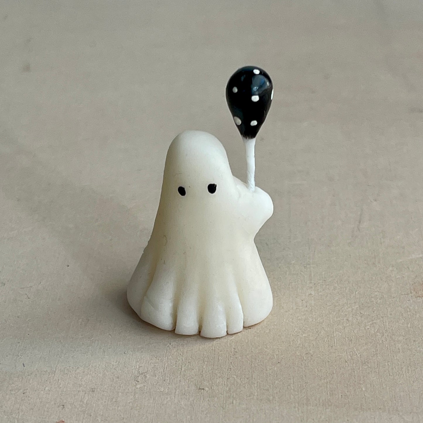Miniature ghost with black polka dot balloon