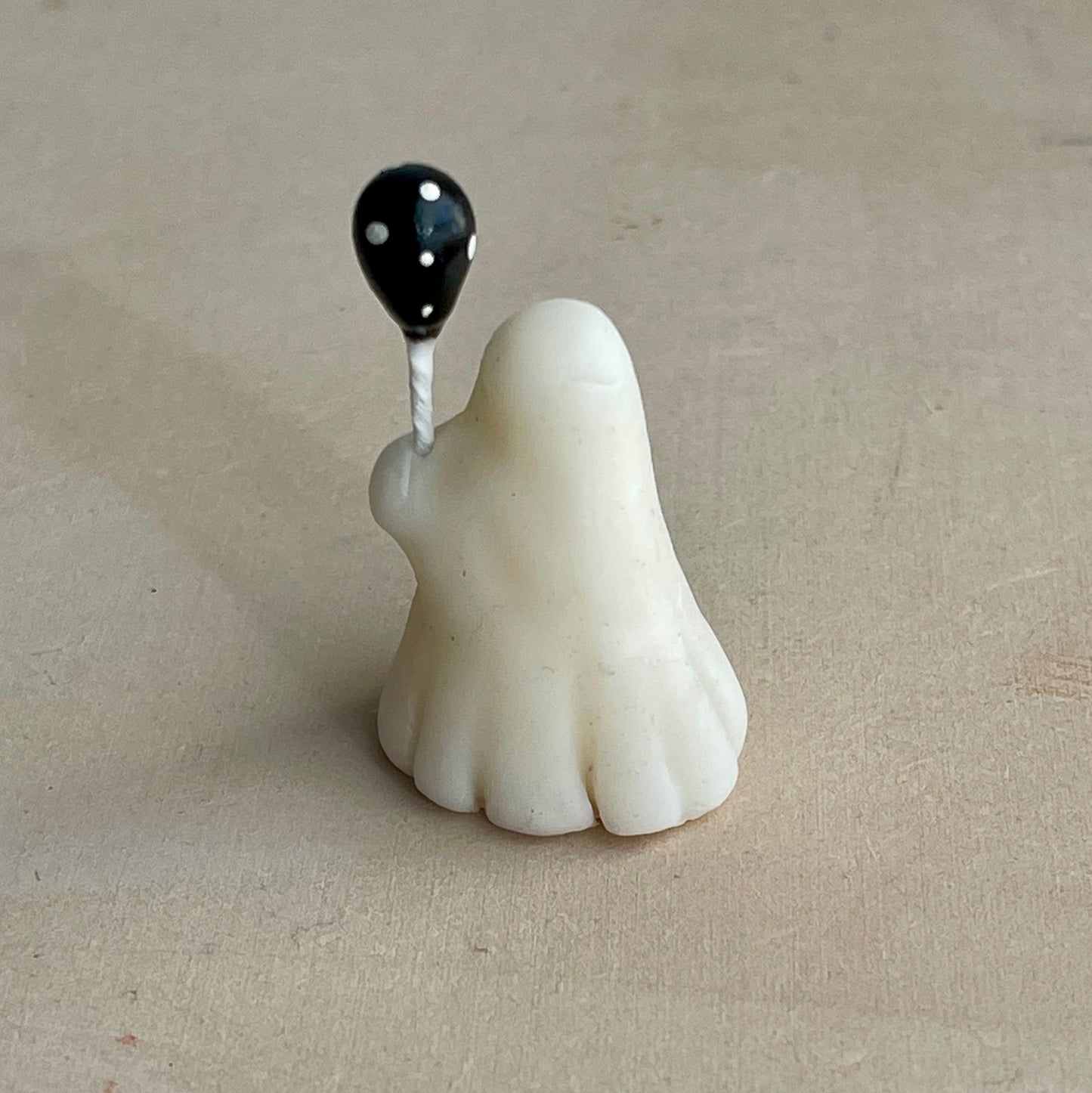 Miniature ghost with black polka dot balloon